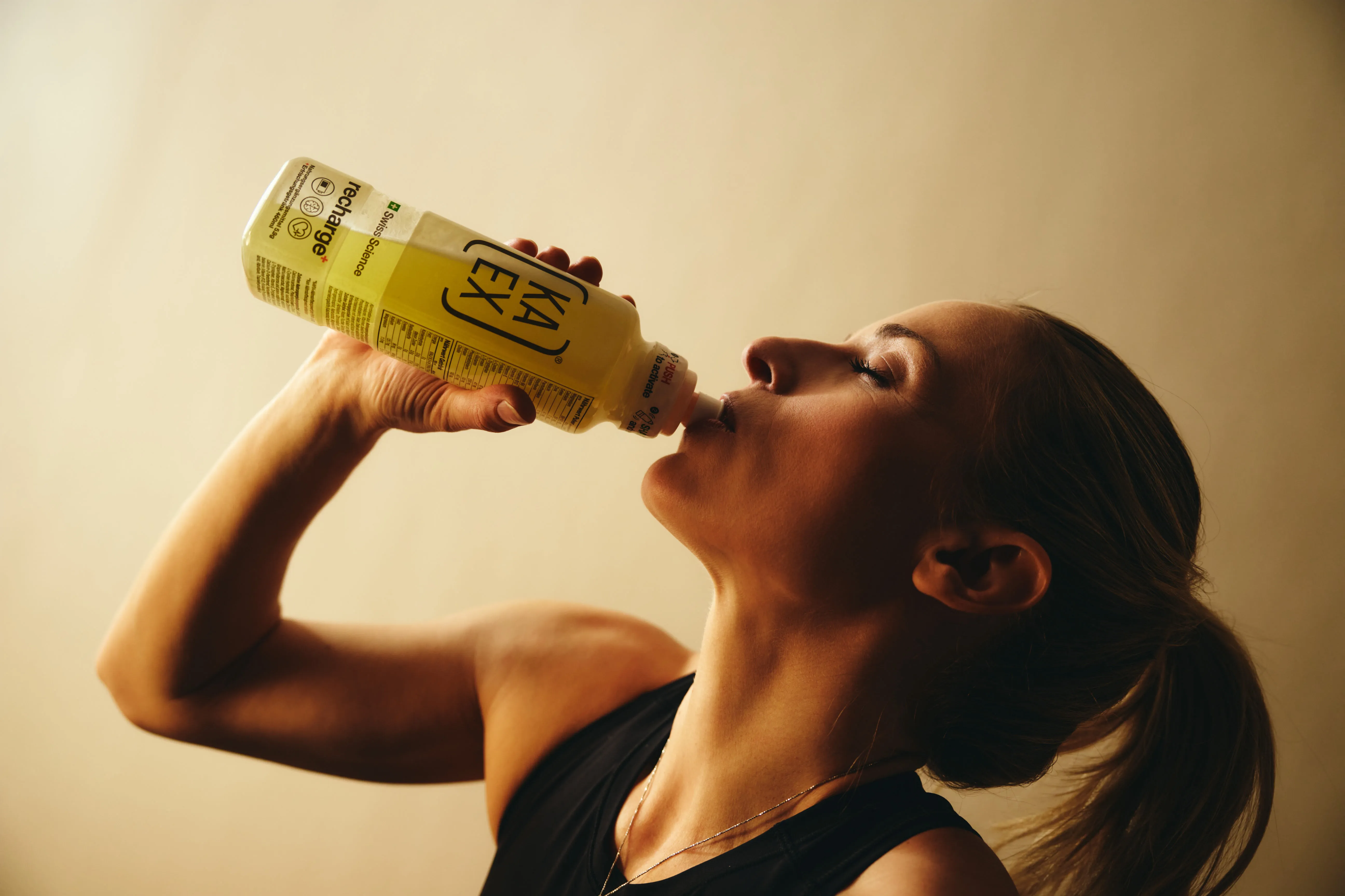 Studio shot of Lara Gut Behrami drinking from a KaEx Recharge Bottle